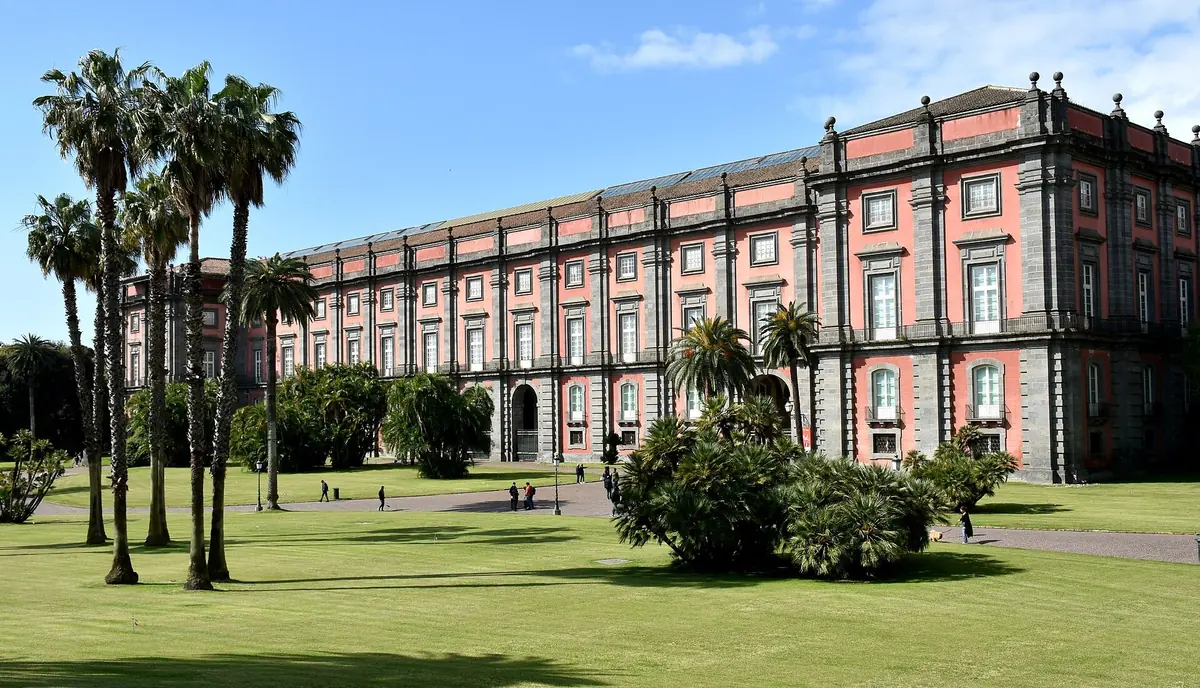 Pelouses et palmiers du Real Bosco di Capodimonte avec le palais royal en arrière-plan