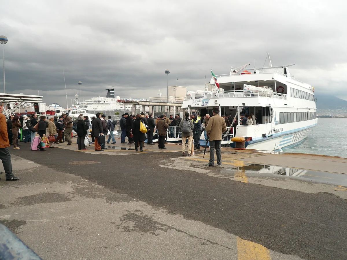 Passengers boarding a hydrofoil to Ischia at a pier in the port of Naples
