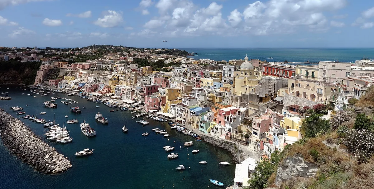 Pastel houses and moored boats of Marina Corricella on Procida seen from above