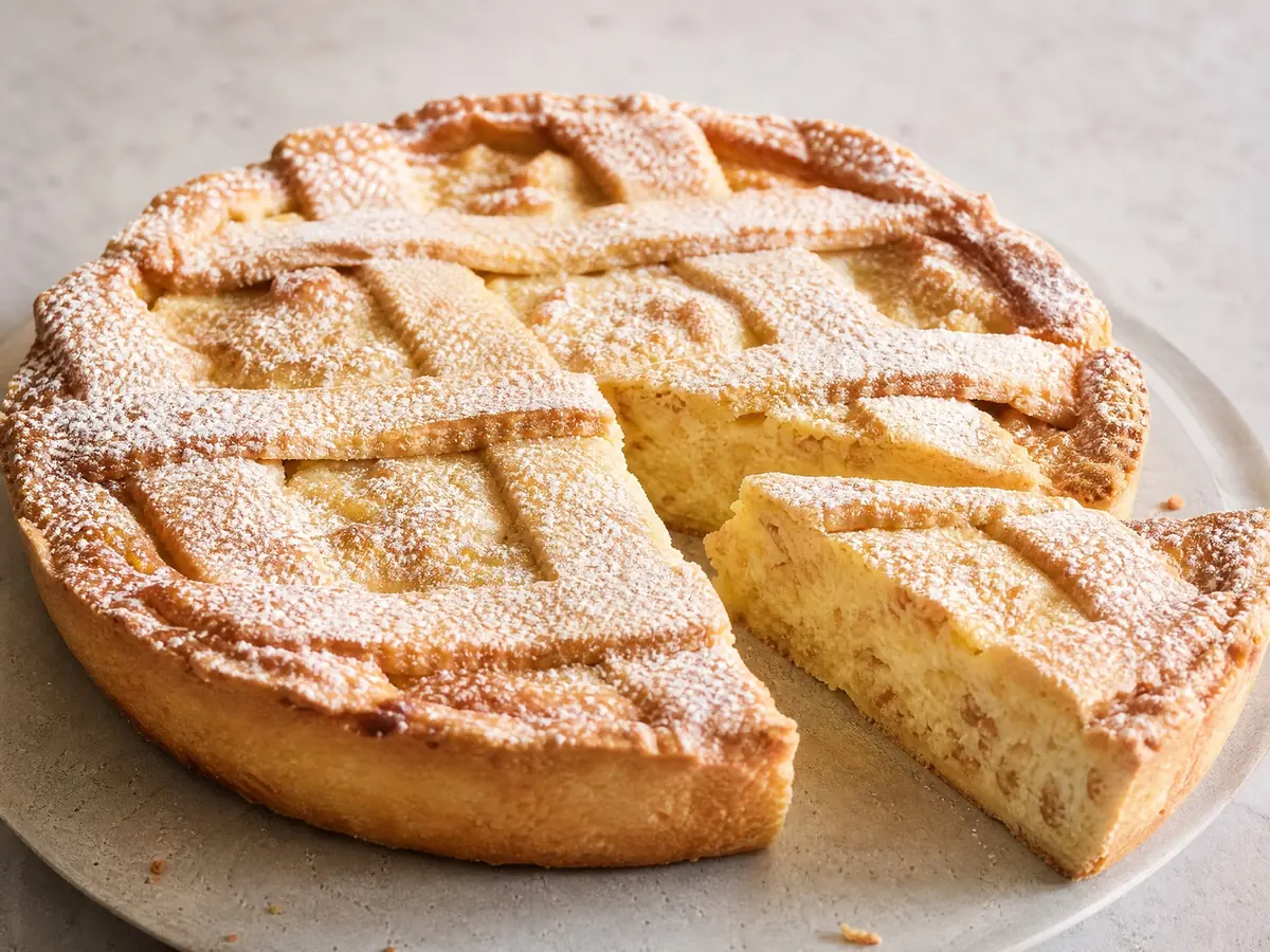 Eine pastiera mit Gitterdeckel, eine Scheibe herausgeschnitten, um die Ricotta- und Weizenfüllung zu zeigen