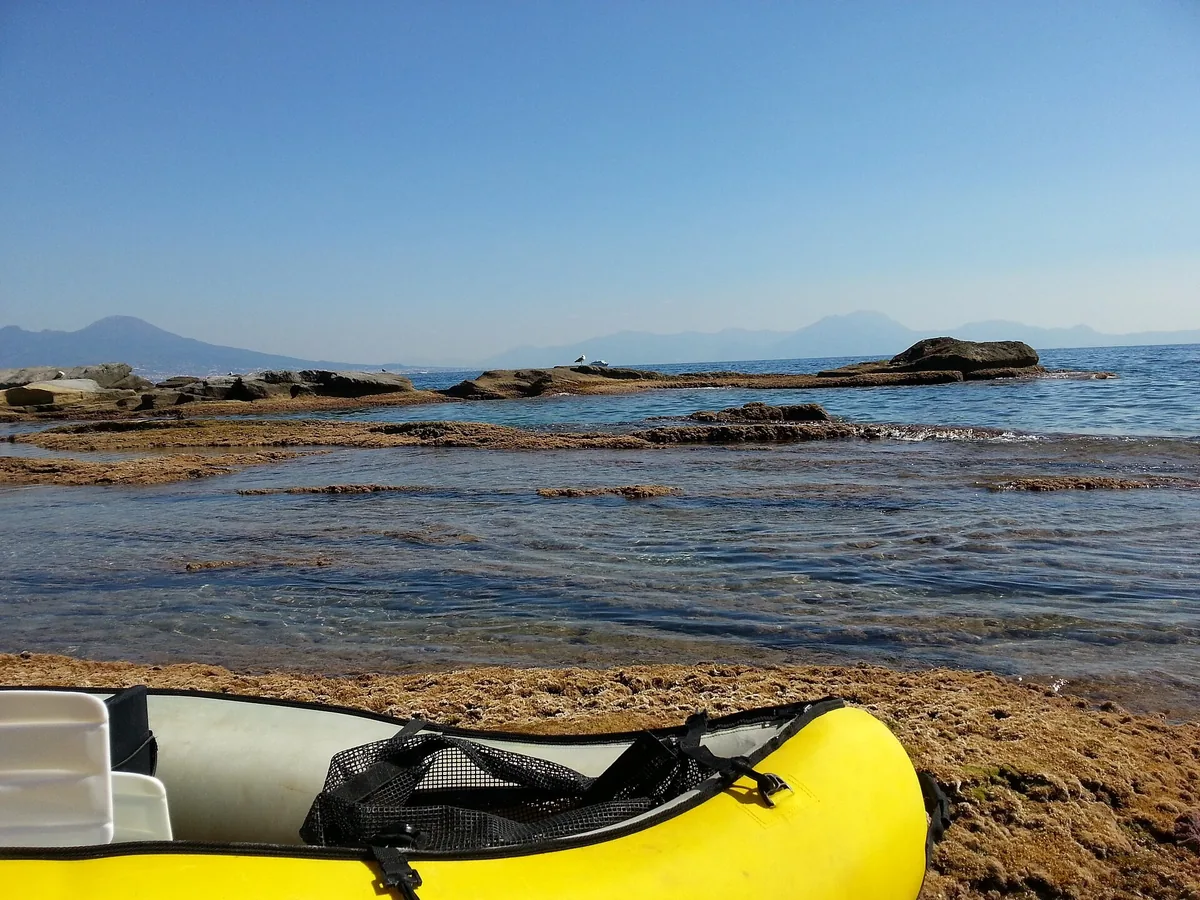 Yellow canoe beached on the rocks at Marechiaro in the Gaiola marine protected area