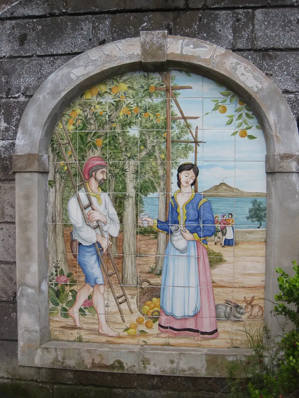 Majolica tile panel of lemon pickers at the entrance to a lemon grove in Sorrento