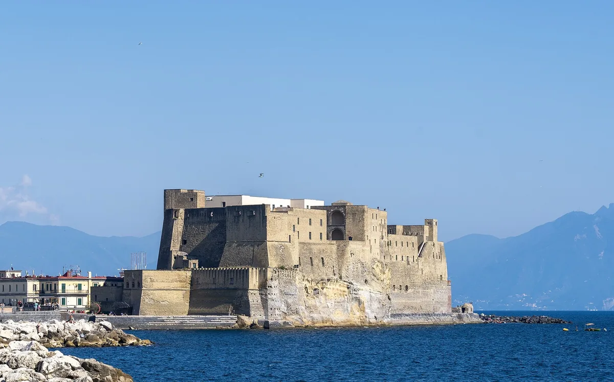 Castel dell'Ovo sur son îlot rocheux dans la baie de Naples sous un ciel dégagé