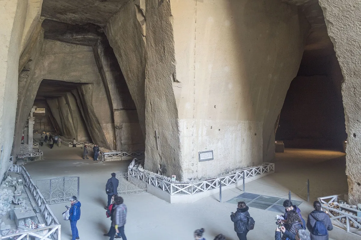 Visiteurs dans la vaste caverne de tuf du cimetière des Fontanelle, dans le Rione Sanità