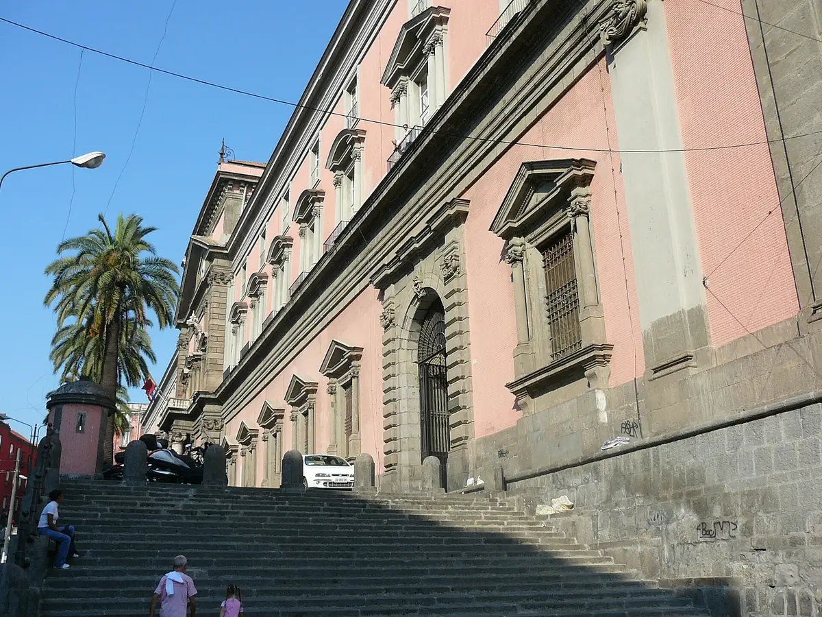 Pink and grey facade of the National Archaeological Museum of Naples above a flight of steps