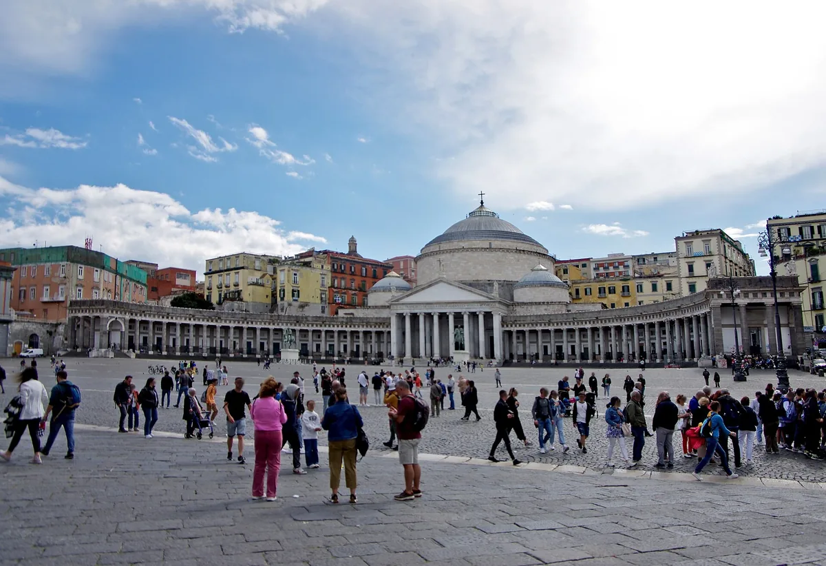 Des visiteurs traversant la Piazza del Plebiscito en direction de l’église à dôme San Francesco di Paola