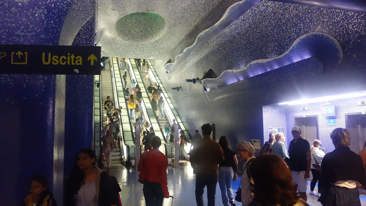 Visiteurs dans le mezzanine en mosaïque bleue de la station de métro Toledo à Naples